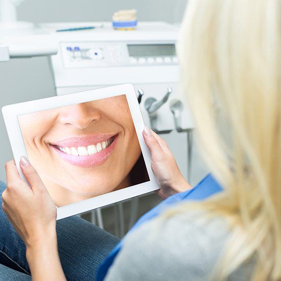 woman looking at smile on tablet